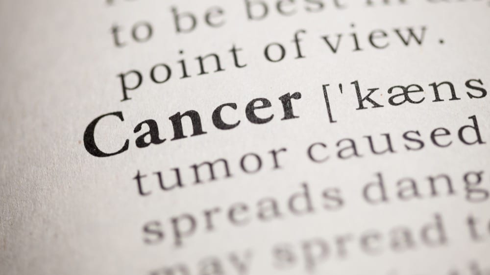 The word Cancer highlighted in bold at the beginning of a page from a dictionary. It is providing the definition of Cancer.